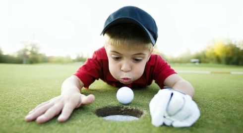 Young Boy Cheating at Golf